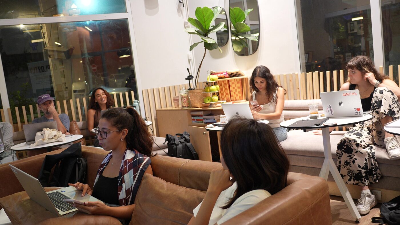 People working on laptops on sofas